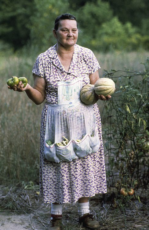 A woman holding fruits and vegetables in her hands.