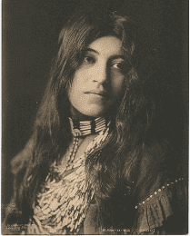 A woman with long hair wearing a necklace.